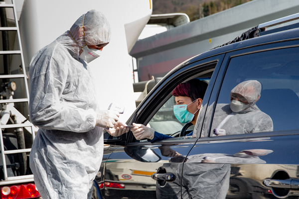 PPE protected doctor checking driver for corona virus